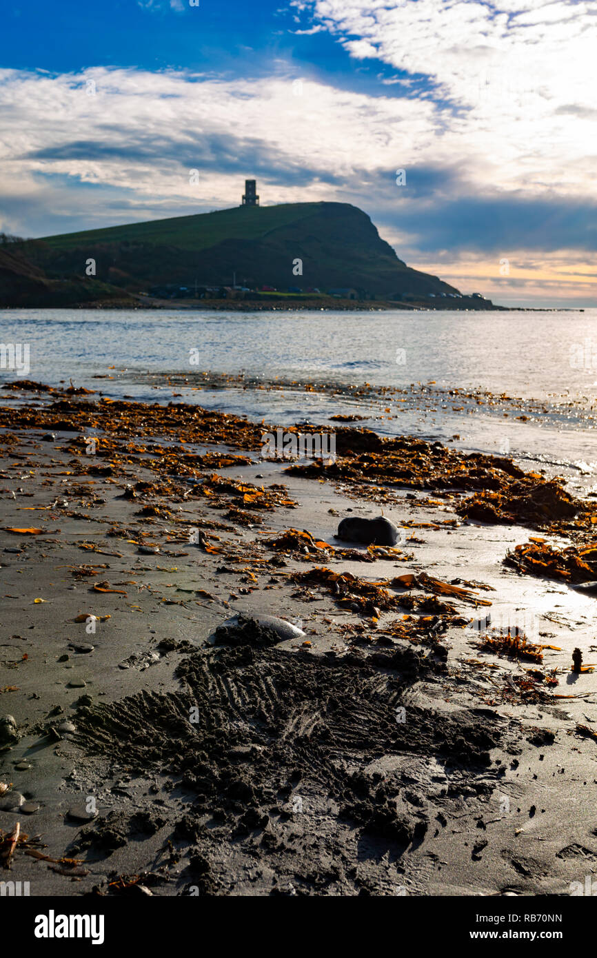 Fotografia del paesaggio in orientamento verticale della spiaggia di recentemente definite segni sulla spiaggia sabbiosa con bay, Cliff e Clavell torre in background. Prese a Foto Stock