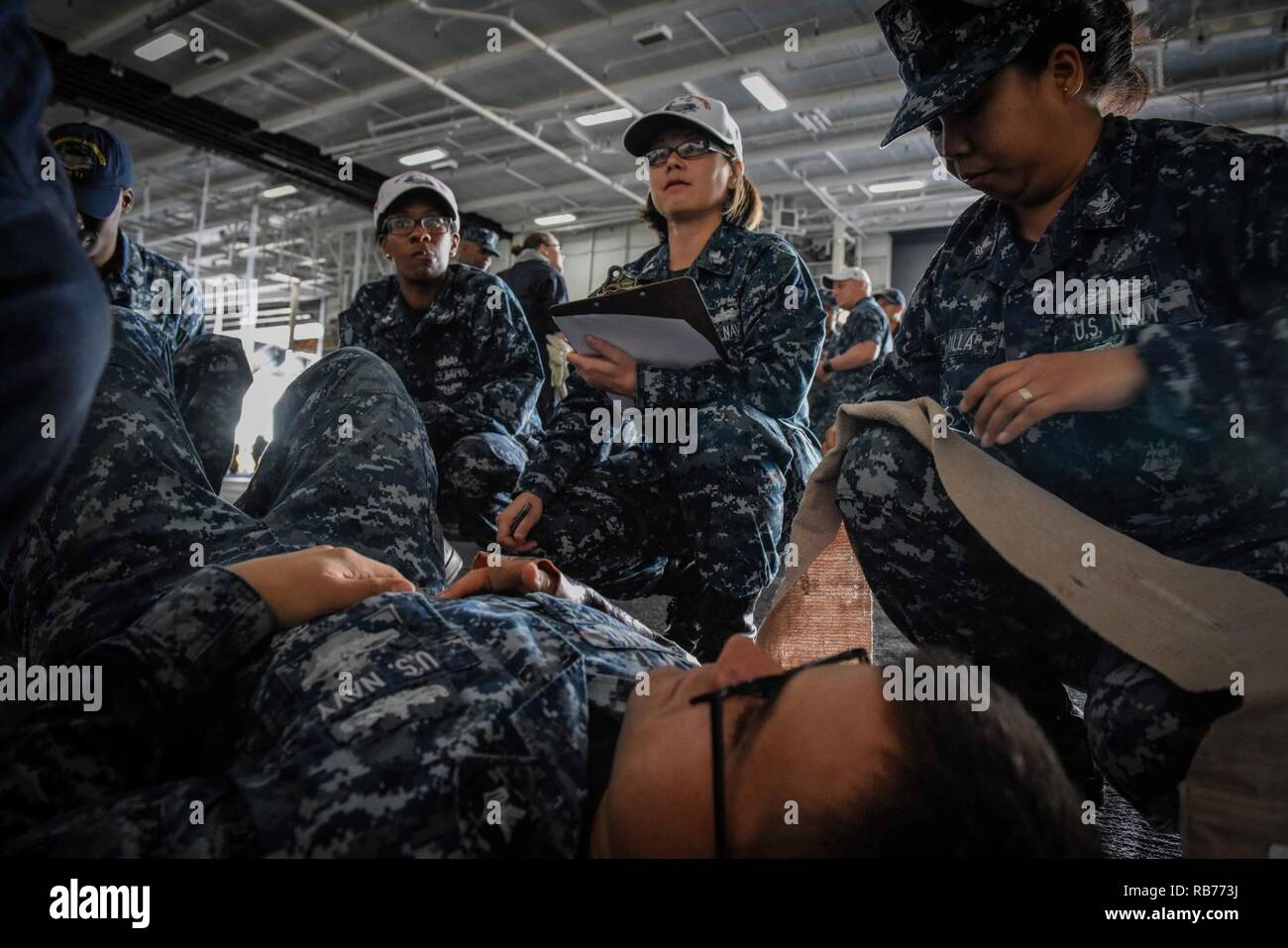 SAN DIEGO (dec. n. 12, 2016) Petty Officer 1. Classe Olga Carpenter incarica i marinai sul primo soccorso mentre Petty Officer 1. Classe Giacobbe Yelland imita un terzo grado braccio elettrico di masterizzazione con un puntello durante una nave-ampio esercizio di formazione a bordo della portaerei USS Theodore Roosevelt CVN (71). Theodore Roosevelt è attualmente ormeggiate e homeported in San Diego subendo una pianificata la manutenzione pianificata la disponibilità. Foto Stock