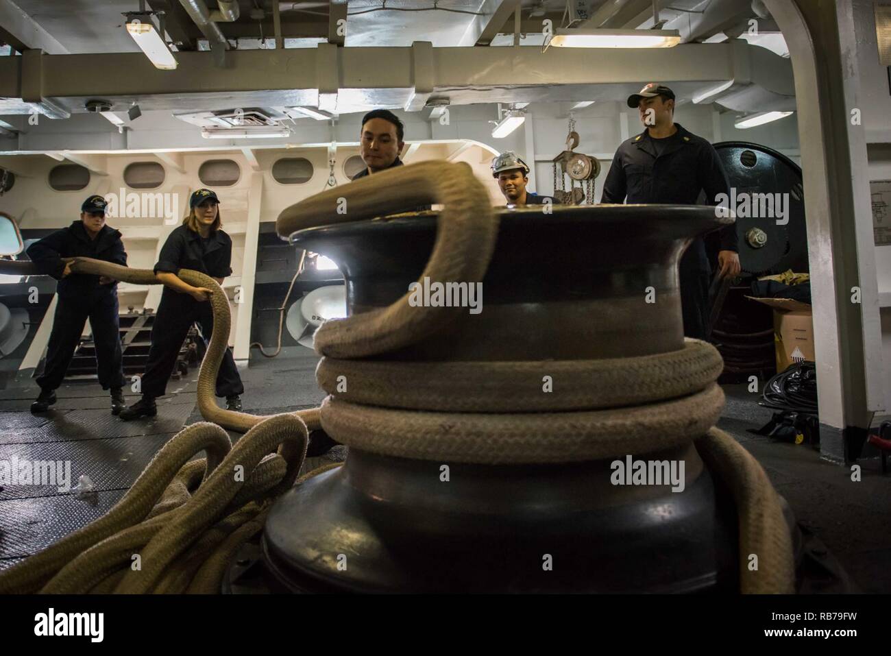SAN DIEGO (dec. n. 15, 2016) marinai heave una linea di ormeggio intorno a un argano nel castello di prua della portaerei USS Theodore Roosevelt CVN (71). Theodore Roosevelt è ormeggiata pierside alla Naval Air Station North Island conducendo un rapido esercizio di crociera in preparazione per le prossime prove in mare. Foto Stock
