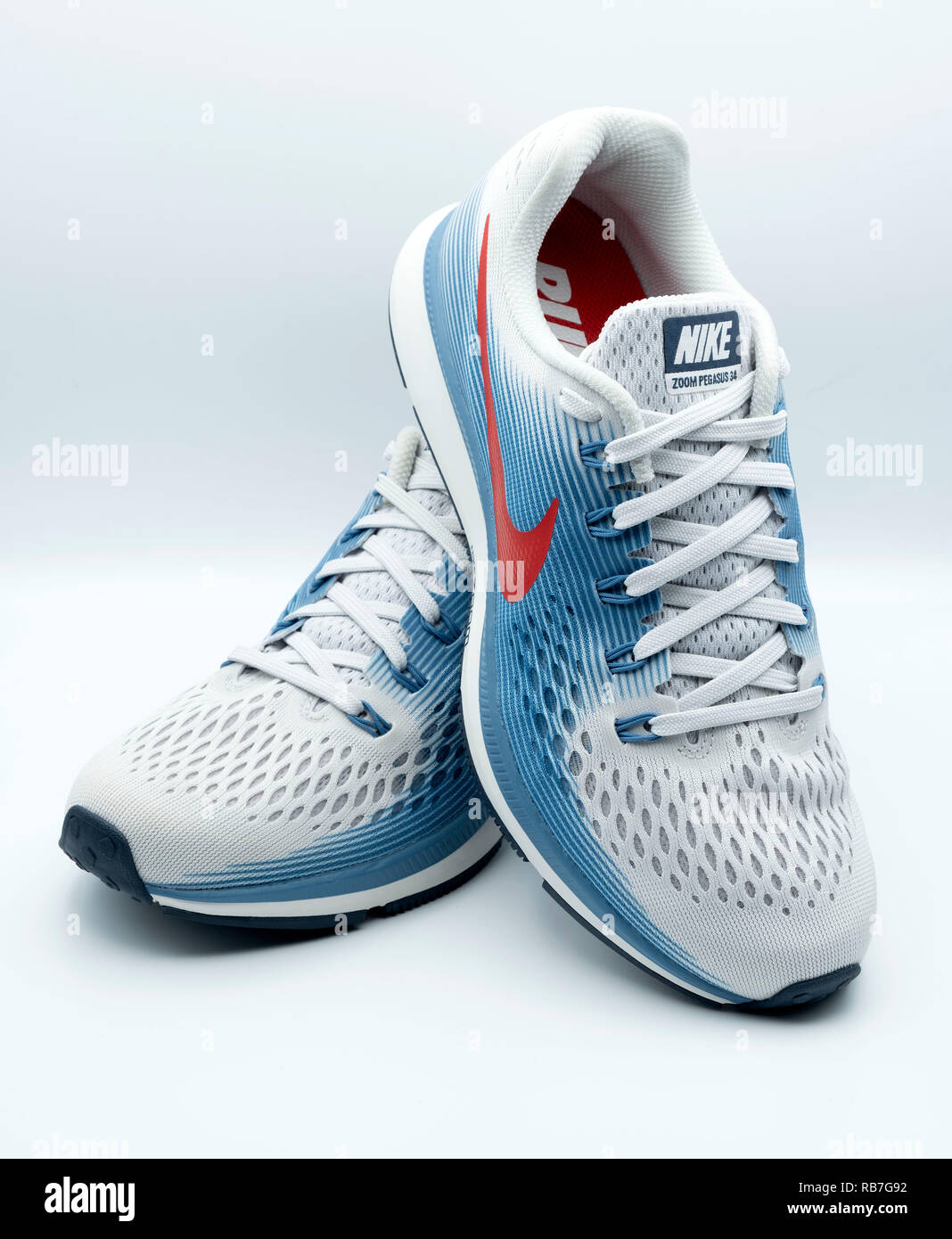 Due Nike Pegasus 34 blu, bianco e rosso sneakers isolati su sfondo bianco Foto Stock