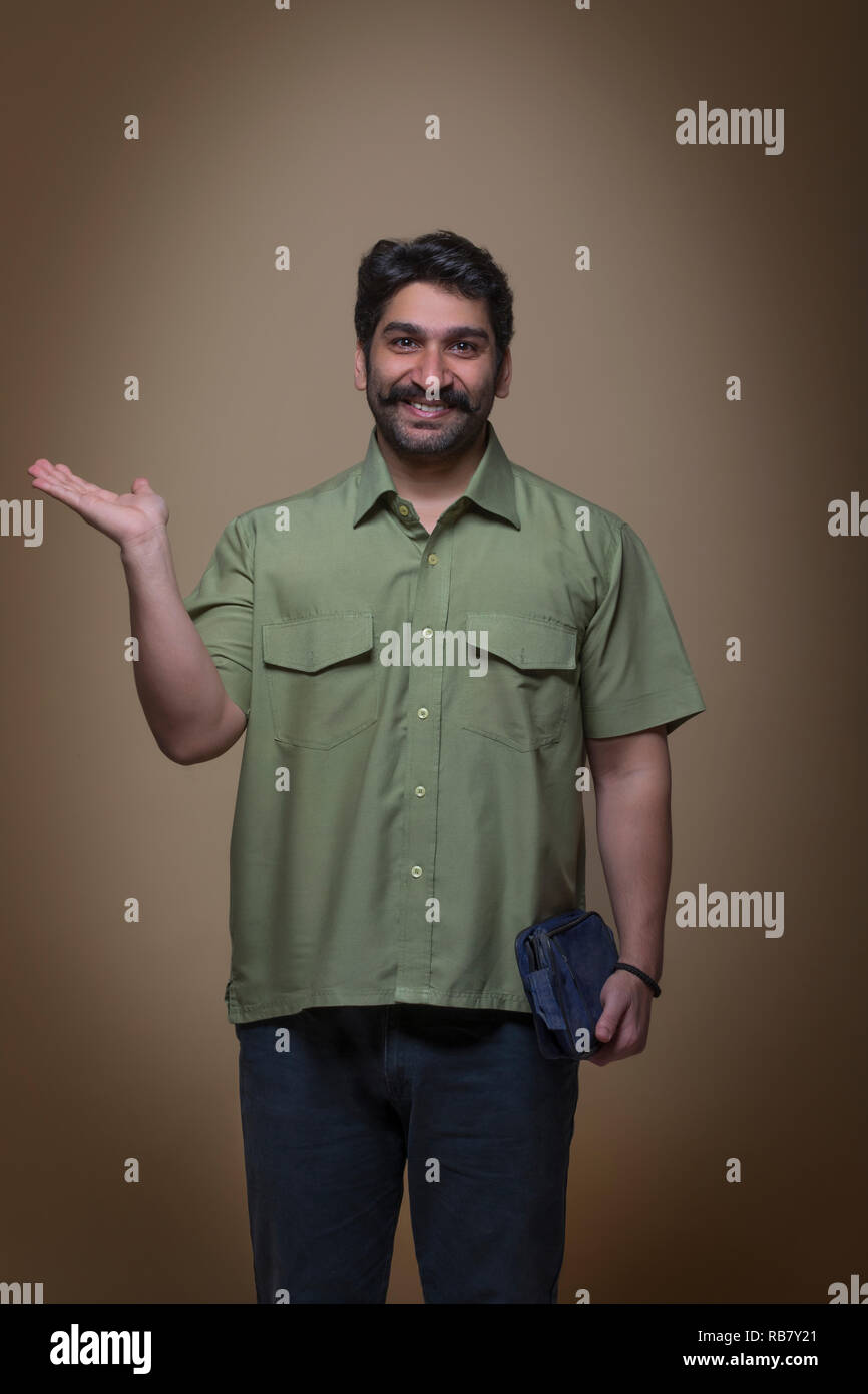 Uomo con una piccola borsa in una mano e mostrando palm. Foto Stock