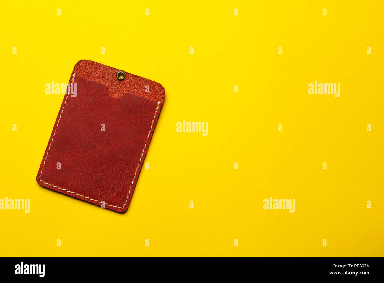 Pelle di colore rosso il titolare della carta mock up su sfondo giallo. Manicotto di titolari di carte di credito in tasca. Piatto sfondo laici. Il concetto di business. Foto Stock