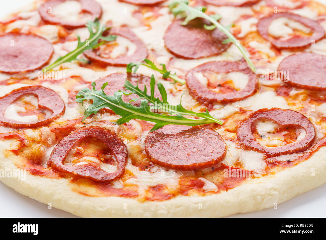 Close-up shot di a forma di cuore la pizza con salsiccia per pizza, mozzarella e rucola. Il giorno di San Valentino romantico concetto alimentare. Foto Stock