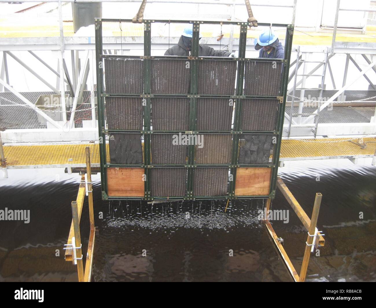 Un telaio di supporto di contenimento olio grezzo imbevuto di tamponi in schiuma viene sollevato dalla vasca di prova presso la National Oil Spill Response la ricerca e le fonti di energia rinnovabili impianto di prova di Leonardo, New Jersey, giovedì 8 dicembre 2016. Le pastiglie sono state utilizzate per dimostrare la fuoriuscita di olio cleanup tecnologia sviluppata da Argonne National Laboratory. (Coast Guard Foto Stock