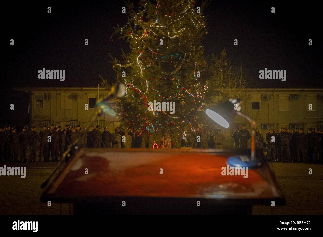 Soldati dal comando Inoltra Post e i loro alleati della NATO assistere ad un albero di Natale Illuminazione sul Camp Marechal de Lattre de Tassigny, Kosovo, dic. 17. La struttura ad albero lighting è stata seguita da una esibizione del gruppo musicale "Gajmor" e una piccola vacanza a tema per la ricezione. Foto Stock