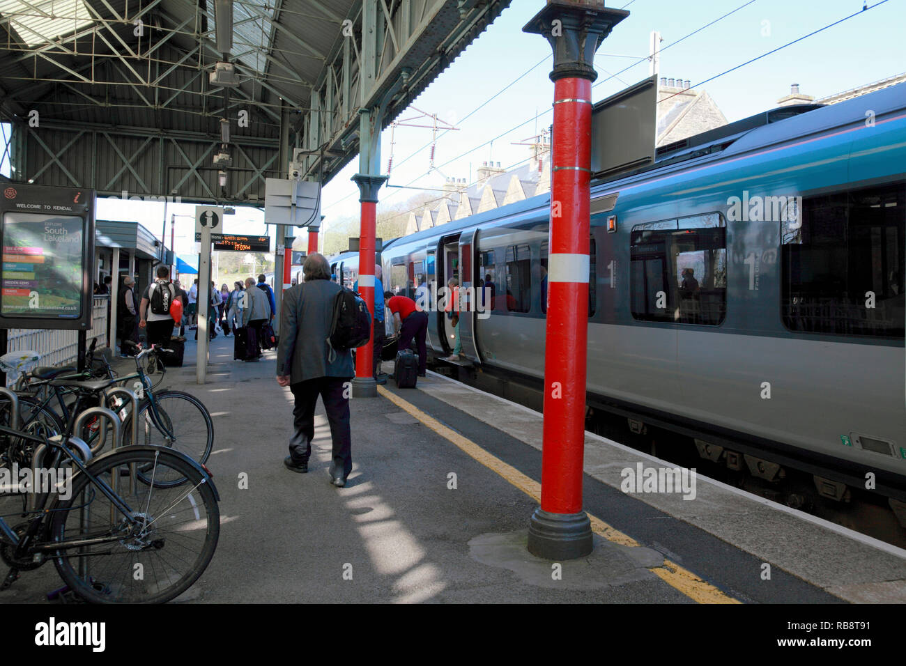 I passeggeri di scendere un TransPennine Express treno alla piattaforma 2 in corrispondenza della stazione Oxenholme nel distretto del lago, Cumbria Foto Stock