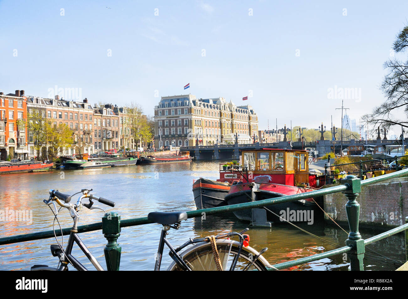 Vista lungo il fiume Amstel verso Hogesluis bridge e InterContinental Amstel Hotel, Amsterdam, Olanda Settentrionale, Paesi Bassi Foto Stock
