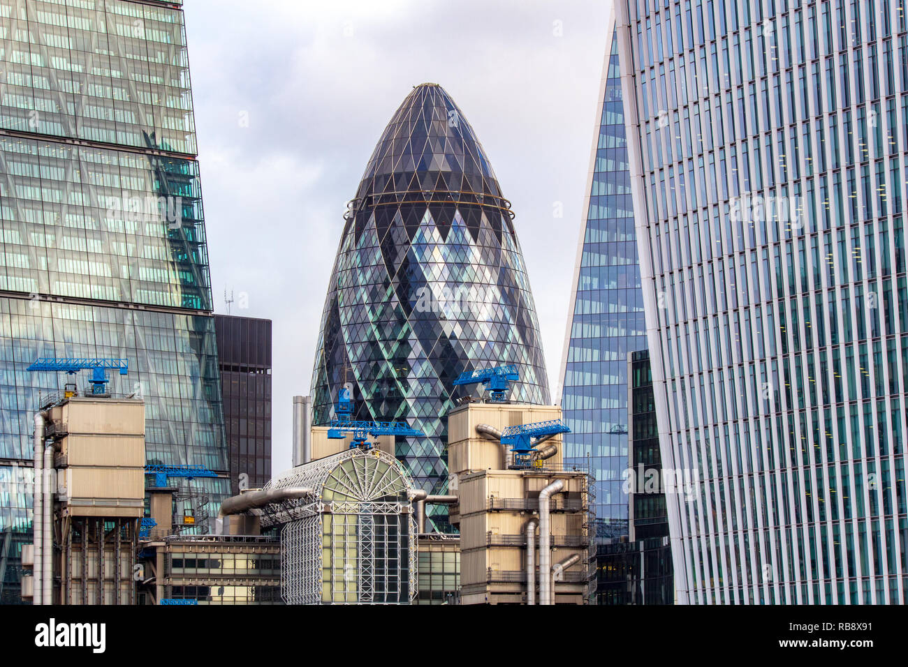 Il Gerhkin edificio circondato da grattacieli del quartiere finanziario di Londra. Foto Stock