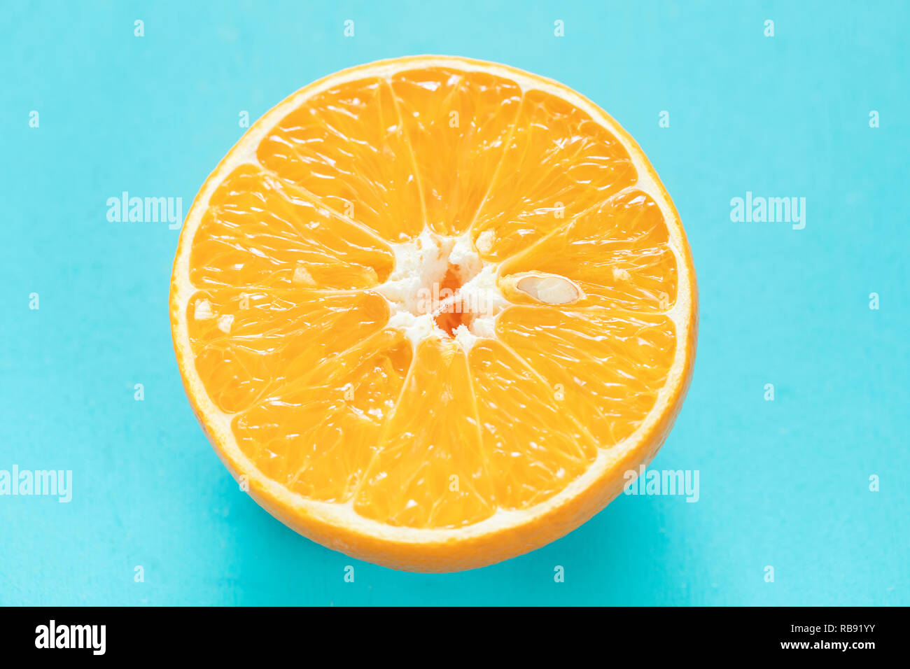 Una metà di succose arance mature su sfondo turchese. Foto Stock
