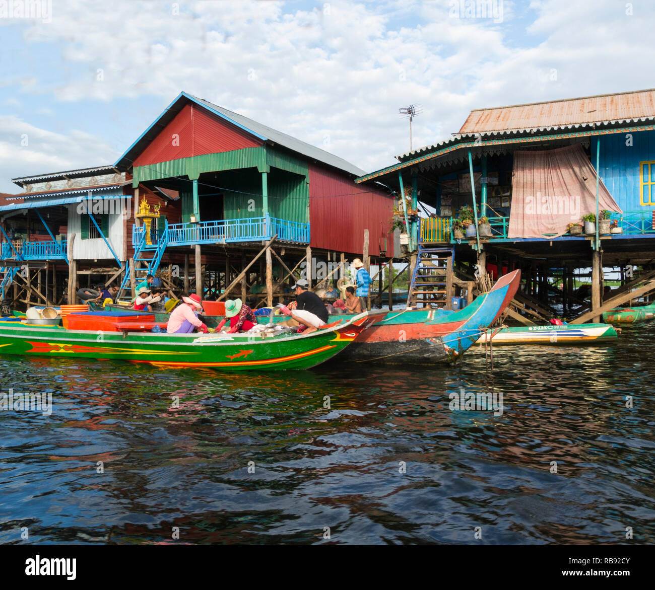 Gli operatori in visita a Kampong Phluk villaggio galleggiante sul Kampong Phluk Fiume Siem Reap Cambogia Asia in canoe vendita di pesce fresco agli abitanti di stilted Foto Stock