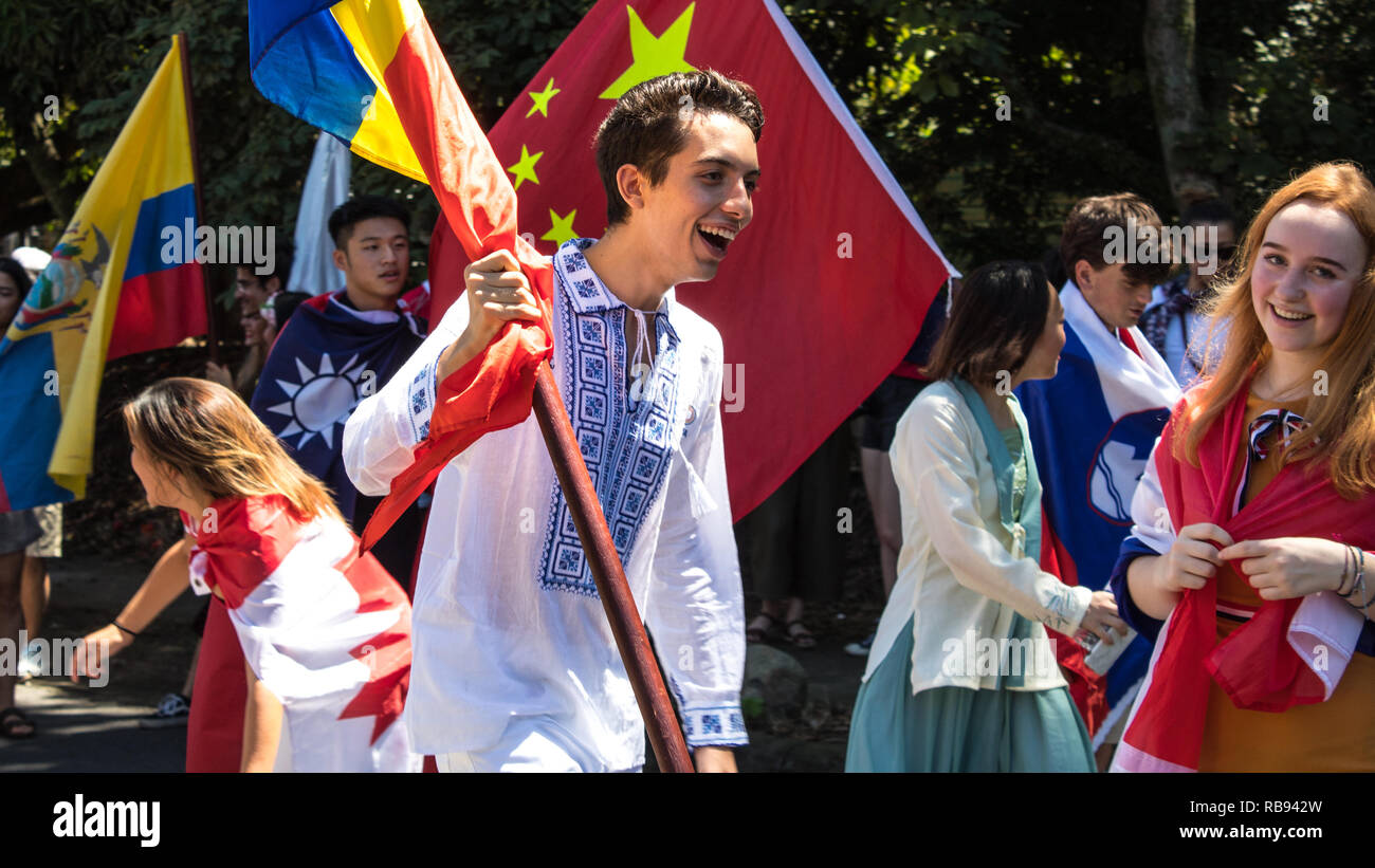 Un allegro ragazzo rumeno sventolare la bandiera nazionale della Romania sta partecipando a una sfilata Foto Stock