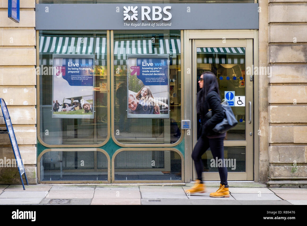 Gli amanti dello shopping sono ritratte oltrepassando un high street branch della Royal Bank of Scotland RBS bank a Bath, Inghilterra, Regno Unito Foto Stock
