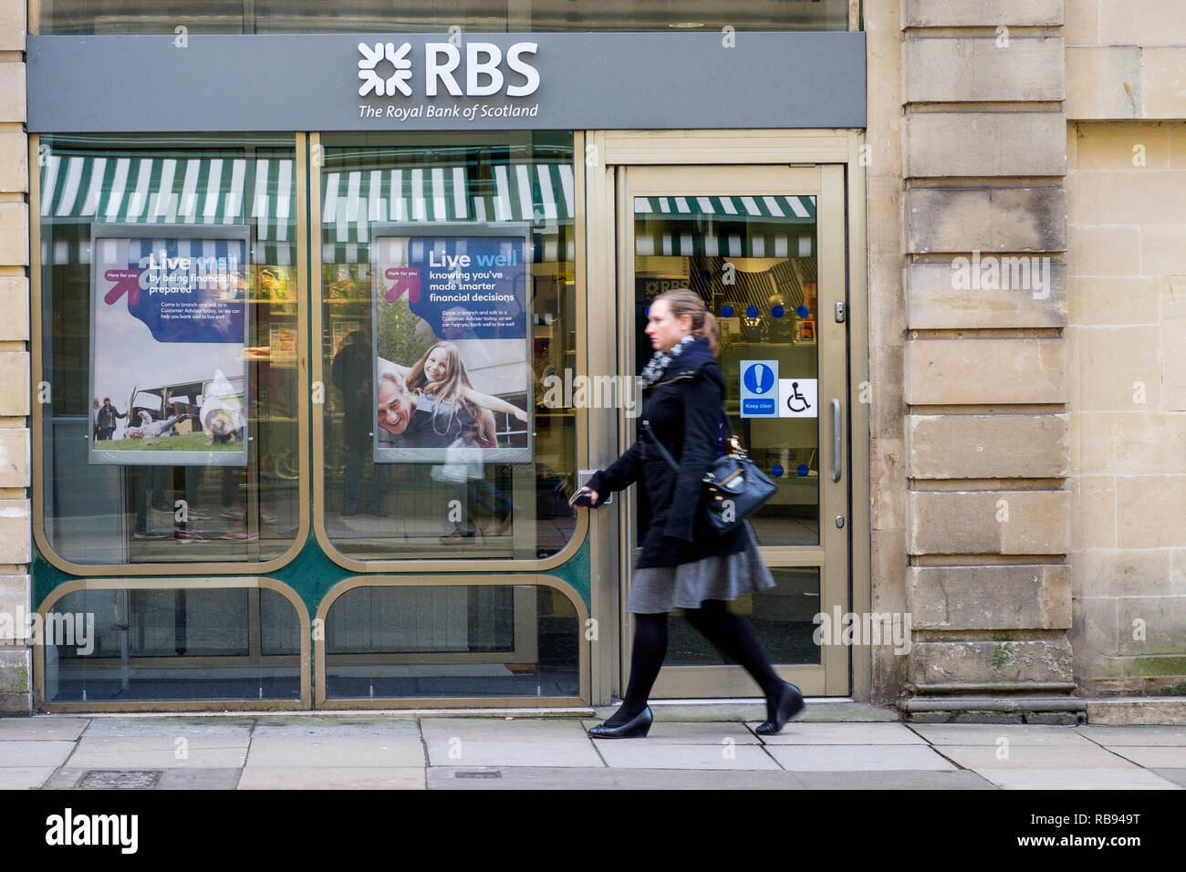 Gli amanti dello shopping sono ritratte oltrepassando un high street branch della Royal Bank of Scotland RBS bank a Bath, Inghilterra, Regno Unito Foto Stock