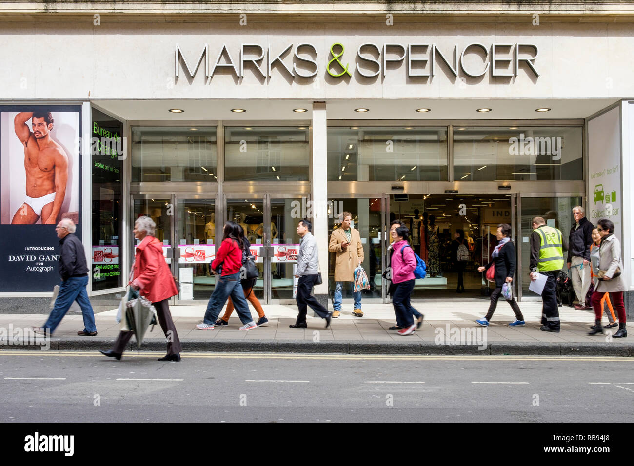 High street acquirenti sono raffigurate oltrepassando un Marks & Spencer department store shop in bagno,l'Inghilterra, Regno Unito Foto Stock