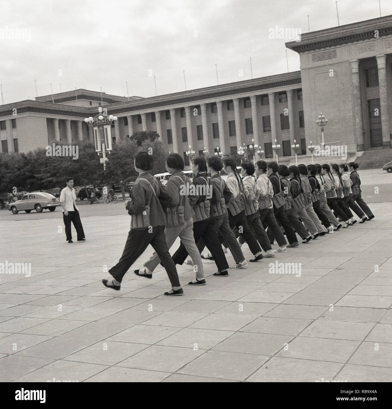 1960, Pechino, Cina, giovani donne cinesi indossando clothiing civile e portante weapoings militare facendo esercizi marching in piazza Tiananmen al di fuori della " Grande Sala del Popolo", il Congresso nazionale del popolo dell'edificio, il parlamento cinese. La stanno preparando per la "Giornata Nazionale", che celebra la fine dei cinesi la guerra civile e la determinazione del popolo della Repubblica sotto il Presidente Mao Zedong. Foto Stock