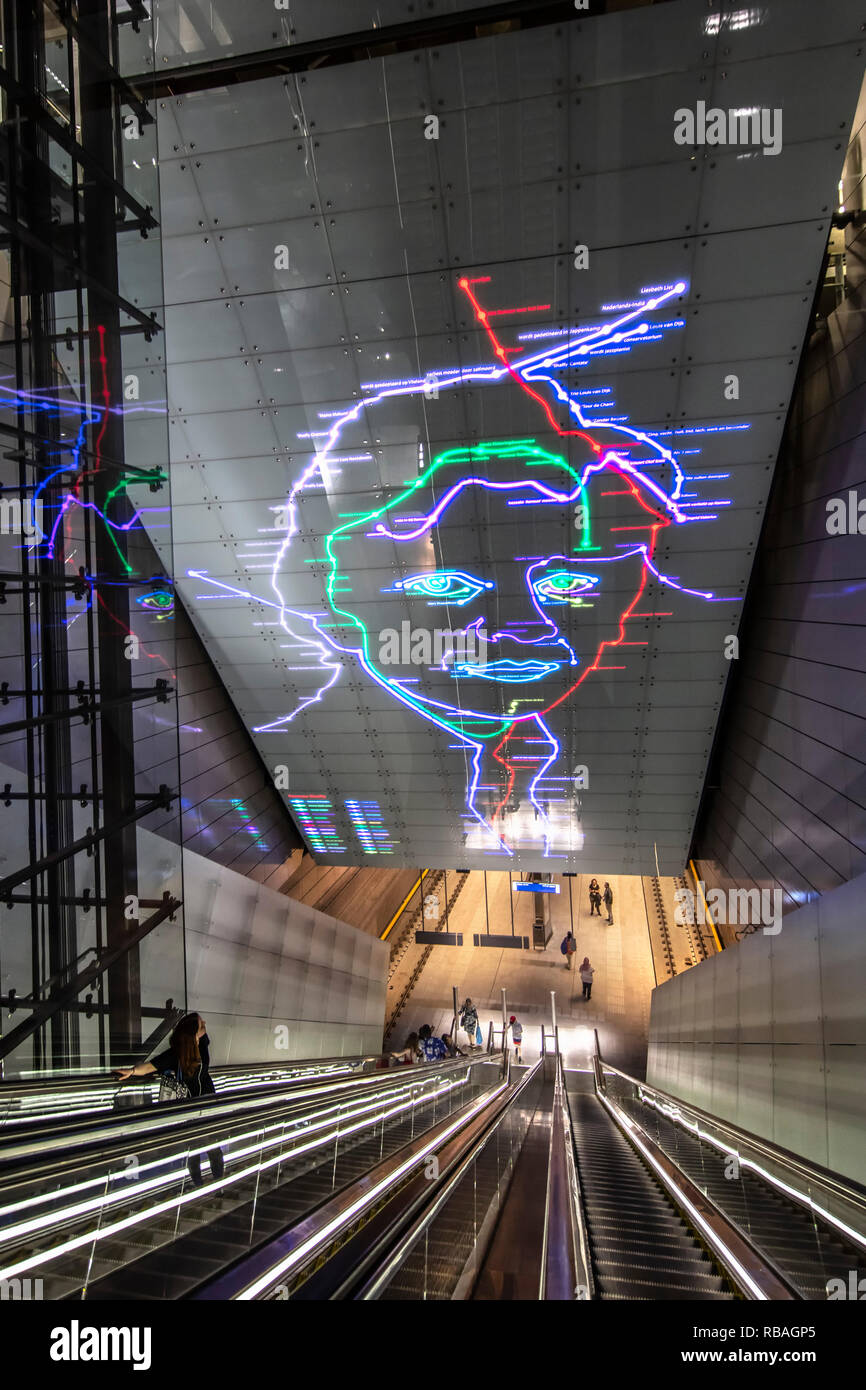 I Paesi Bassi, Amsterdam, alla metropolitana, metro. Nord/Sud linea. Noord/Zuid lijn. Escalator in Vijzelgracht stazione, Artwork "Ramses Shaffy, levenslijnen' Foto Stock