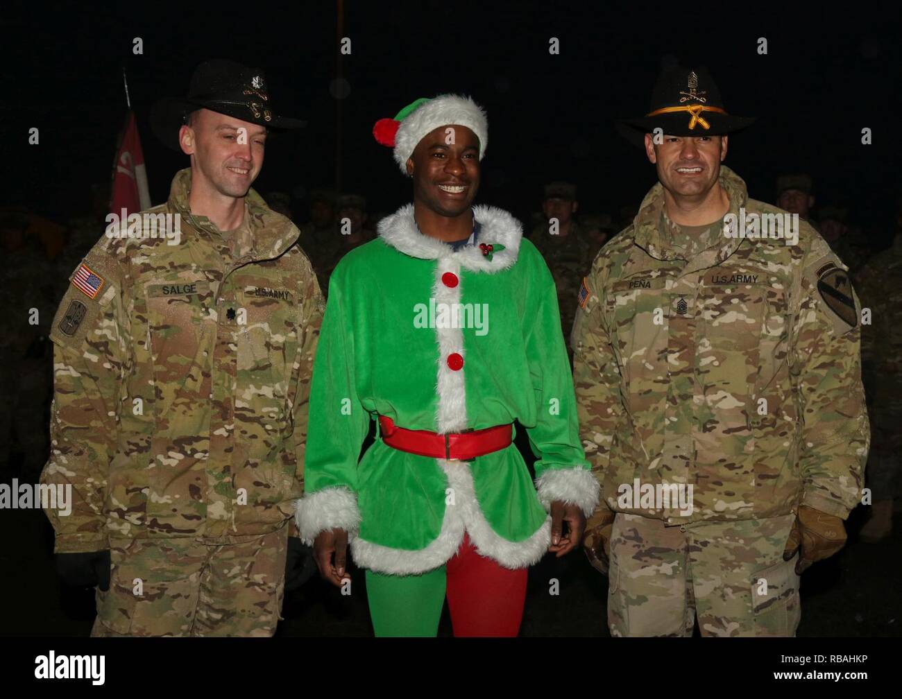 Stati Uniti Esercito Lt. Col. Kevin Salge (sinistra), comandante del secondo battaglione, dodicesimo reggimento di cavalleria, 1° Brigata corazzate contro la squadra, 1° Divisione di cavalleria, U.S. Army Spc. Wilfrantz Cadet (medio) e U.S. Comando Esercito Sgt. Il Mag. Oracio Peña (destra) entrambi assegnati 2-12 CAV, 1° ABCT, 1° CD posano per una foto a Camp Aquisgrana in Germania, 20 dicembre 2018. Soldati dal 1° ABCT, 1° CD hanno partecipato al camp Aachen annuale di illuminazione ad albero come parte dell'uso di vacanza per gli eroi programma. Foto Stock