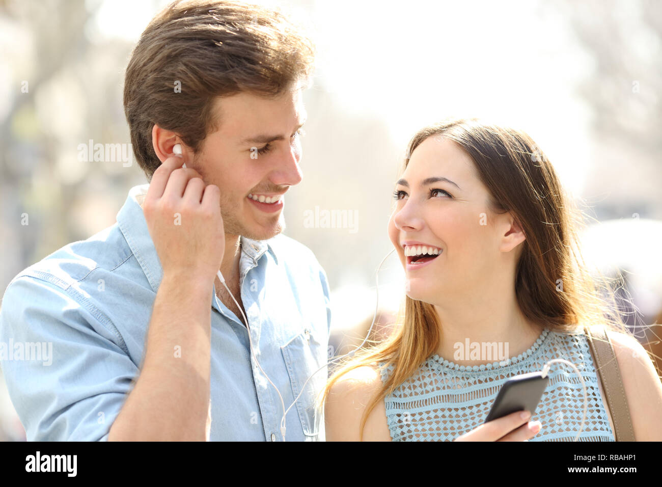 Felice coppia romantica di condivisione di musica online dating in strada Foto Stock