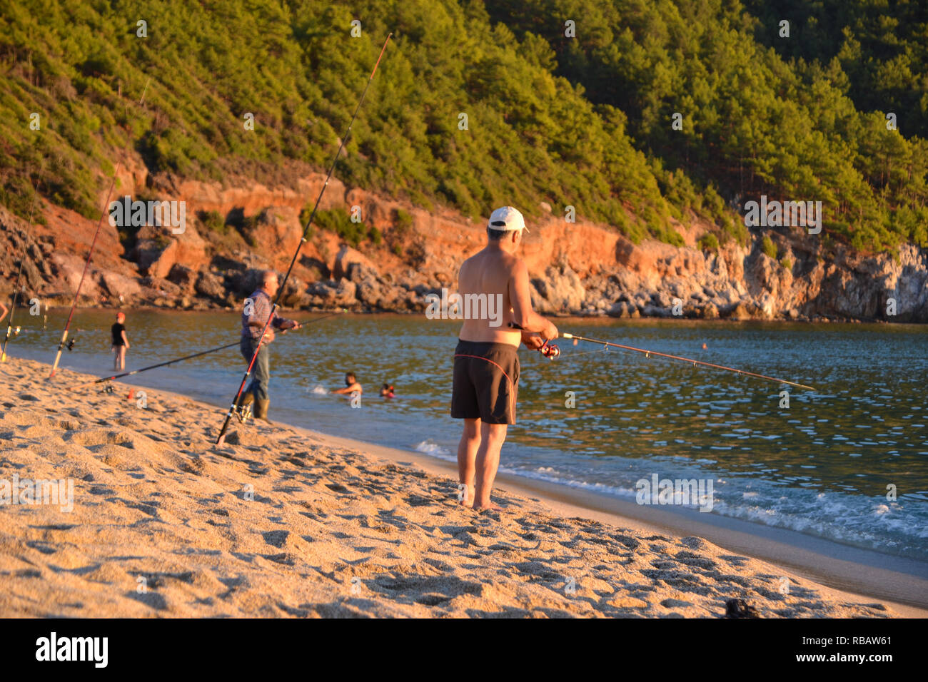 Alanya Turchia ottobre 29, 2018: Serata nella spiaggia di Cleopatra, i pescatori pesca durante il tramonto Foto Stock
