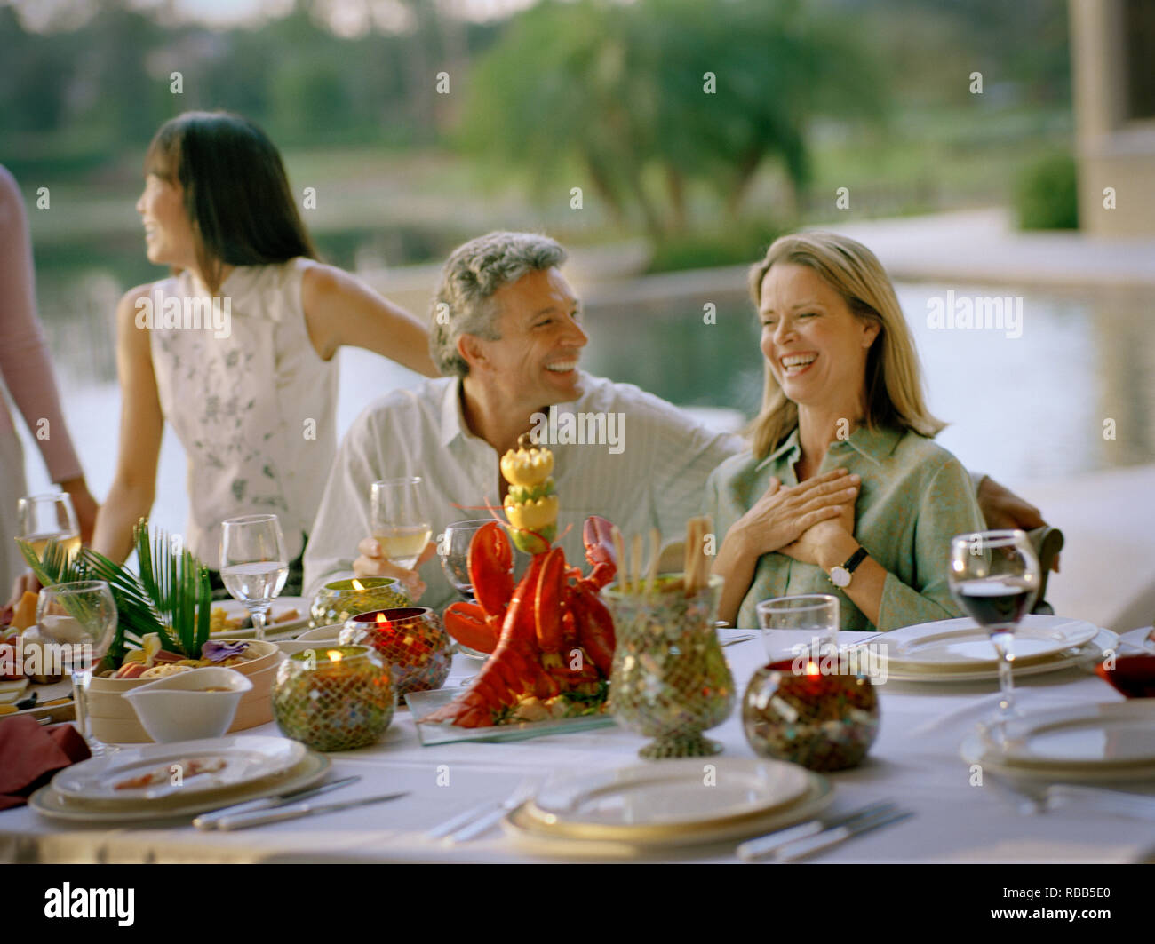 Uomo maturo e sua moglie ridendo durante la cena. Foto Stock