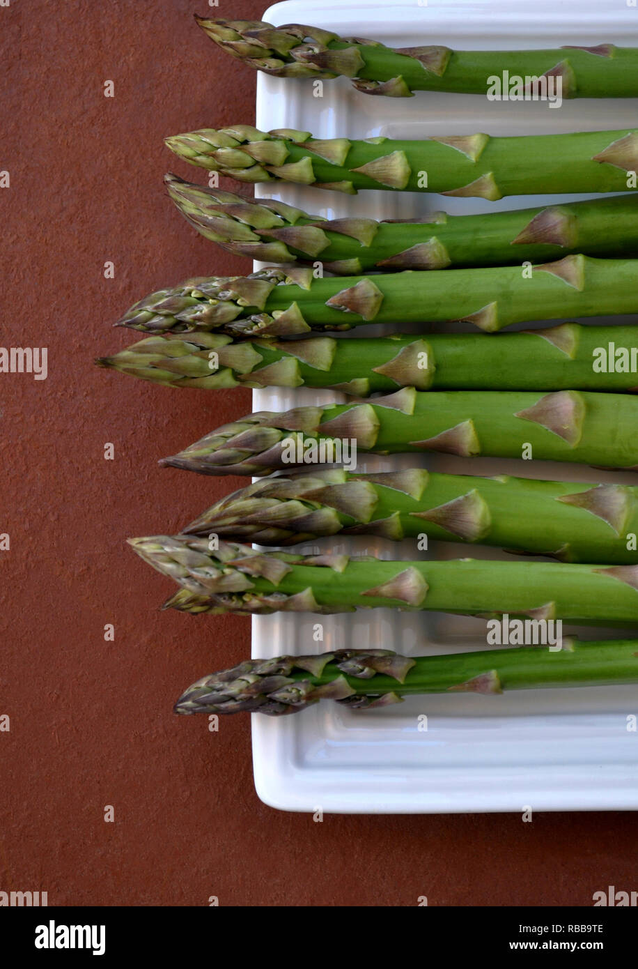 Gli asparagi verdi y un vassoio bianco Foto Stock