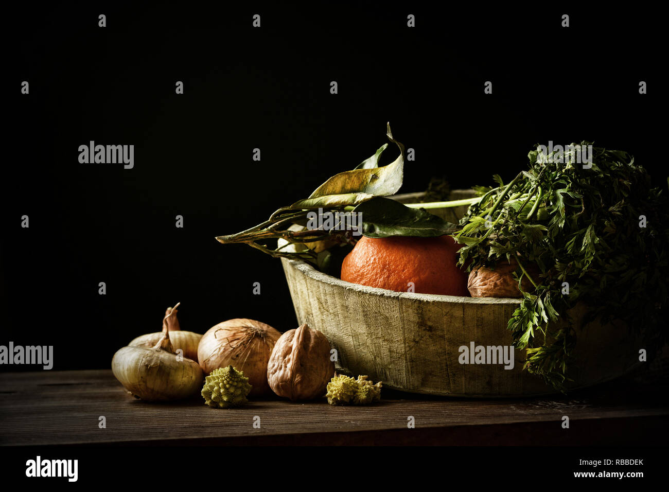 Un assortimento di verdure nella ciotola di legno con sfondo nero - primo piano Foto Stock