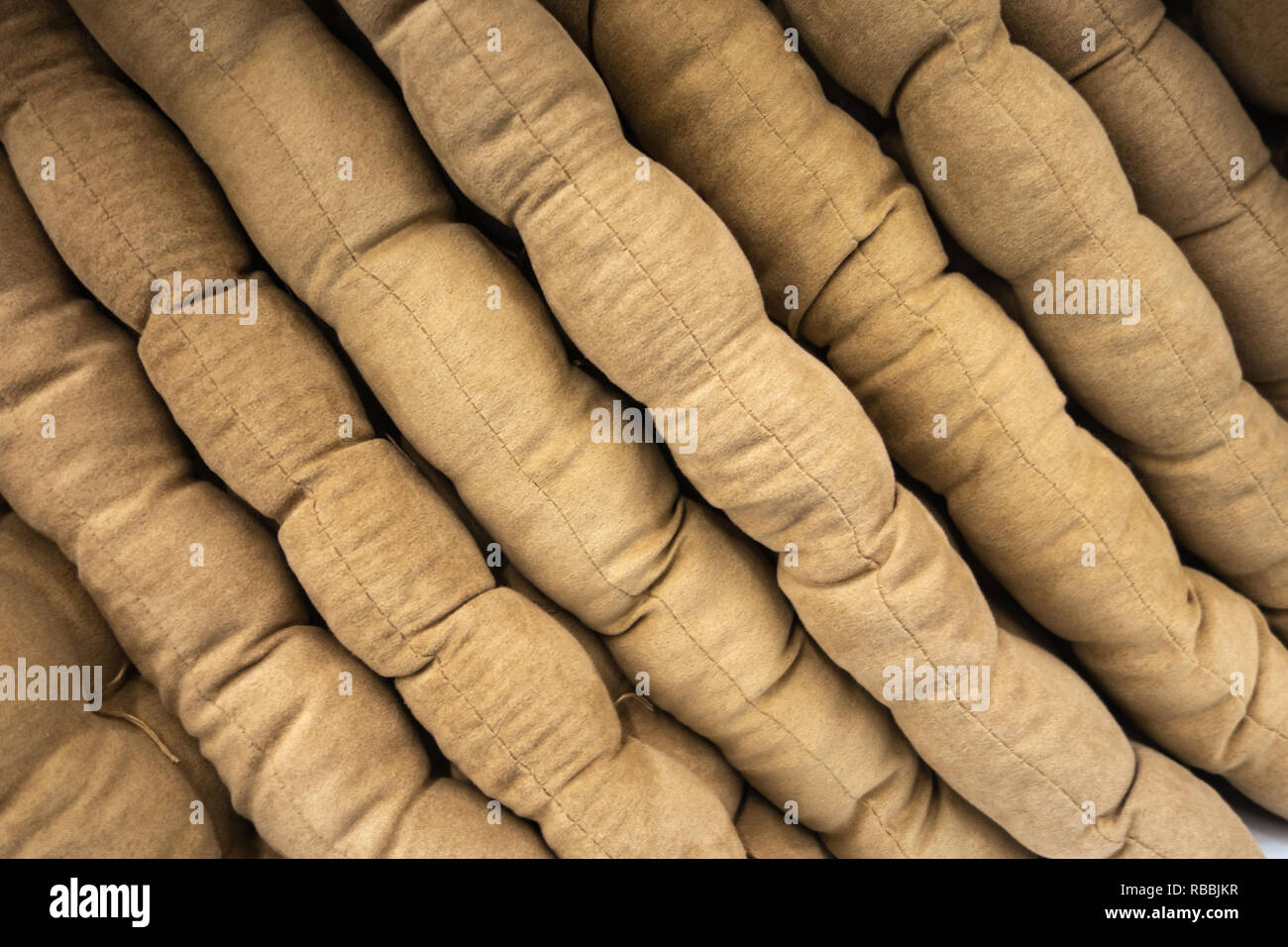 Grigio e beige cuscini sono ripiegate sugli scaffali del negozio. Creative sfondo vintage Foto Stock