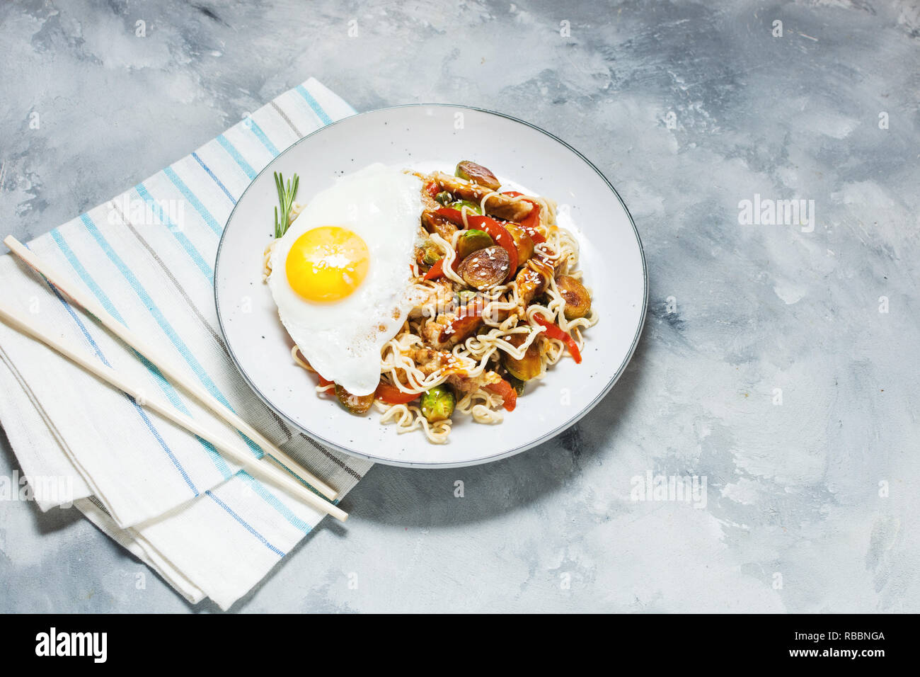 Udon soffriggere tagliatelle con pollo su calcestruzzo sfondo spazio di copia Foto Stock