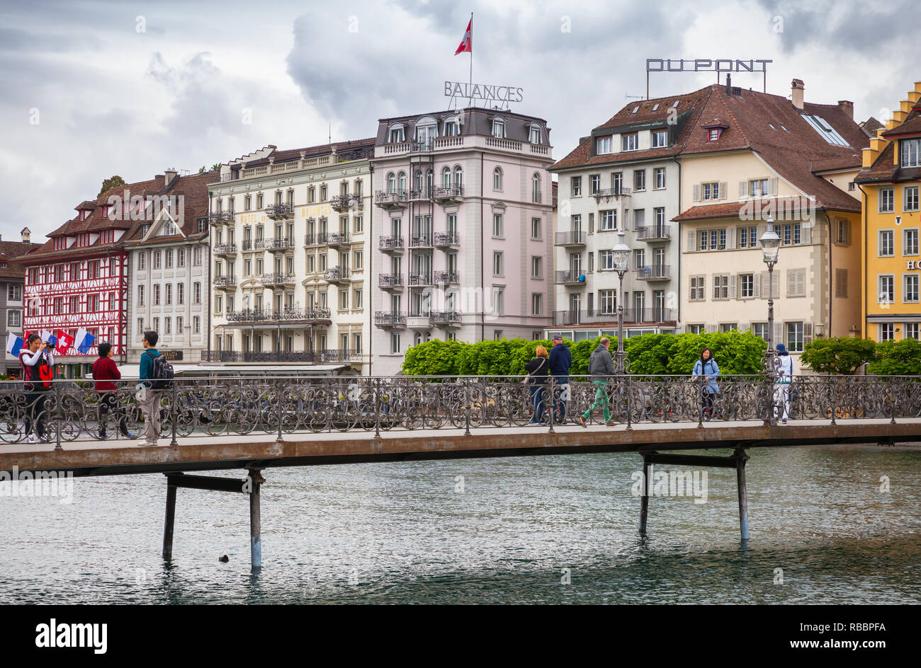 Lucerna, Svizzera - 7 Maggio 2017: Paesaggio urbano della città di Lucerna, la gente a piedi sul ponte vicino all hotel di lusso sul fiume Reuss coast Foto Stock