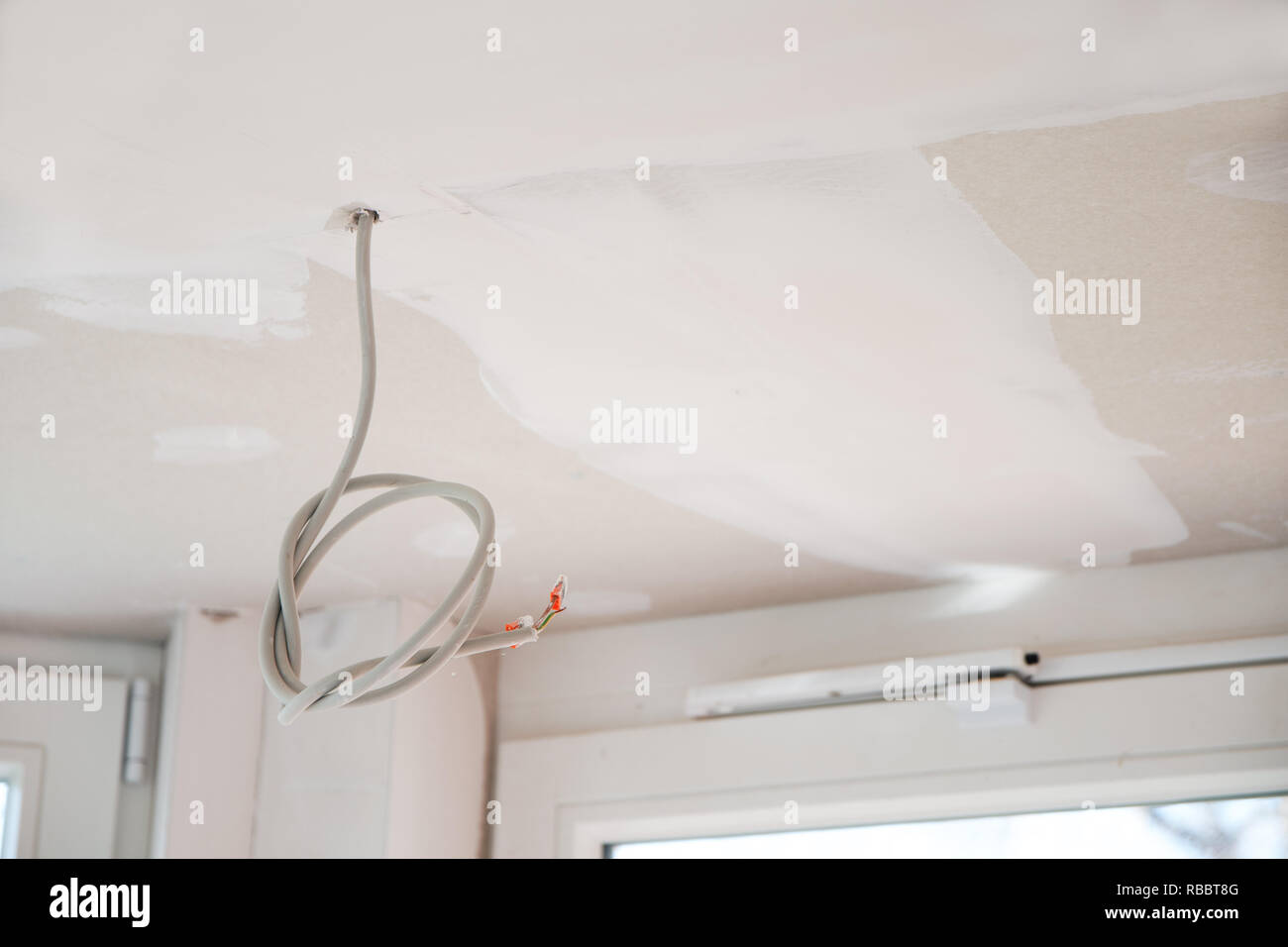 L'installazione elettrica in costruzione a secco il soffitto di una nuova casa ristrutturata, copia dello spazio, messa a fuoco selezionata Foto Stock