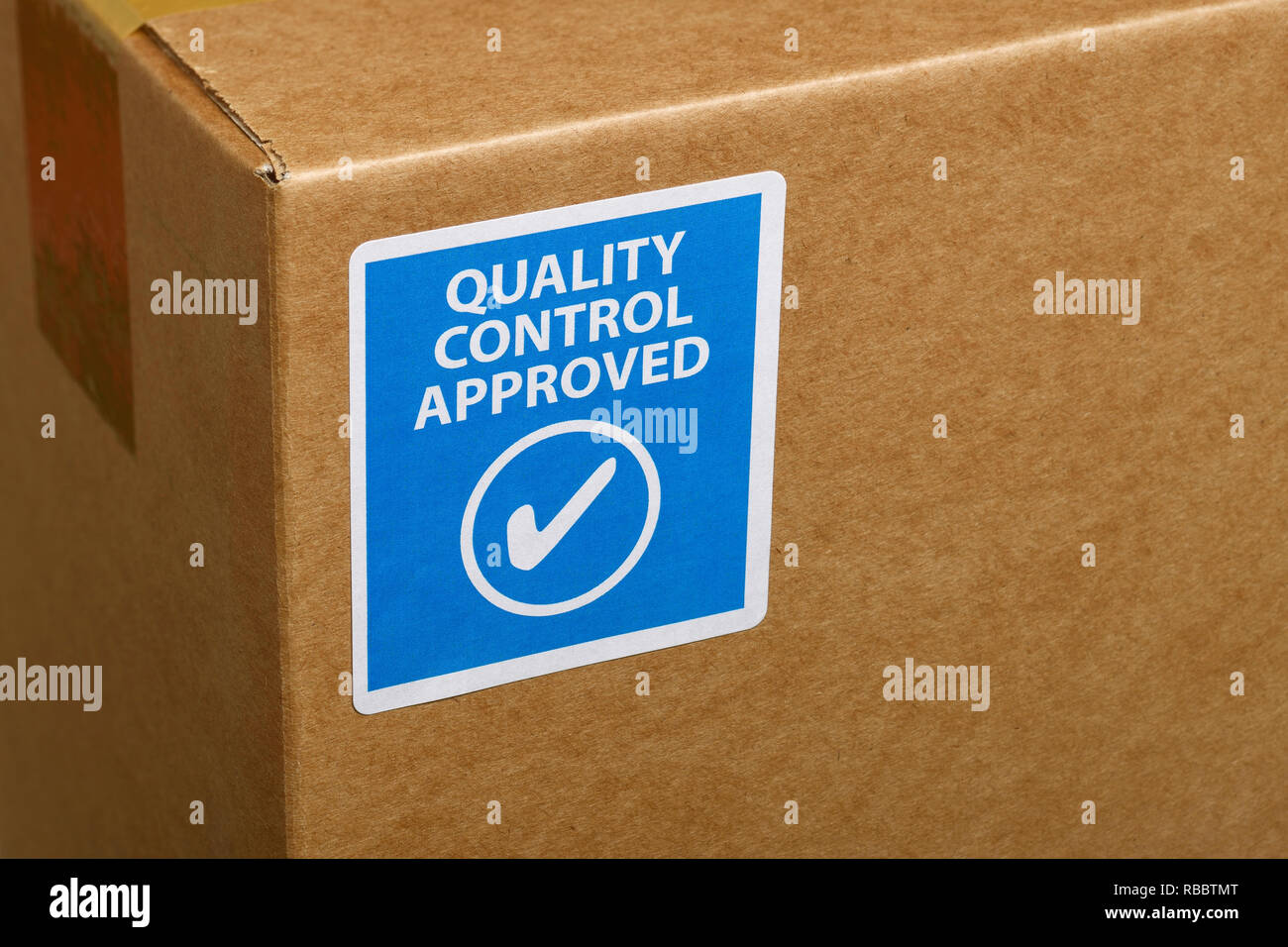 Un controllo di qualità approvato adesivo attaccato all'angolo di una scatola di cartone Foto Stock