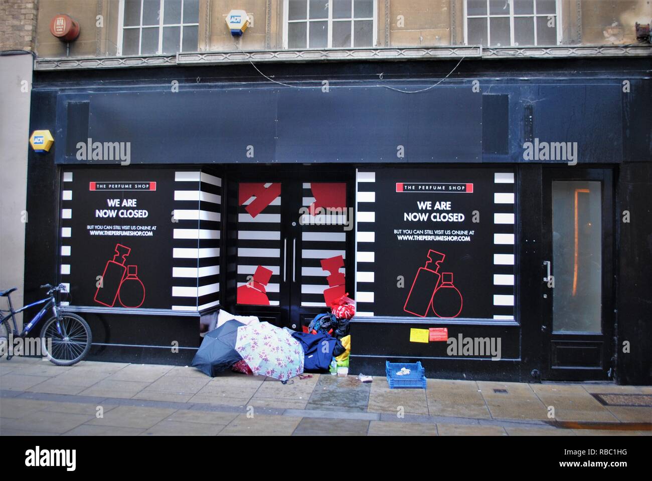 Chiuso il negozio in inverno con i senzatetto averi in modo porta a Cambridge nel centro città Foto Stock