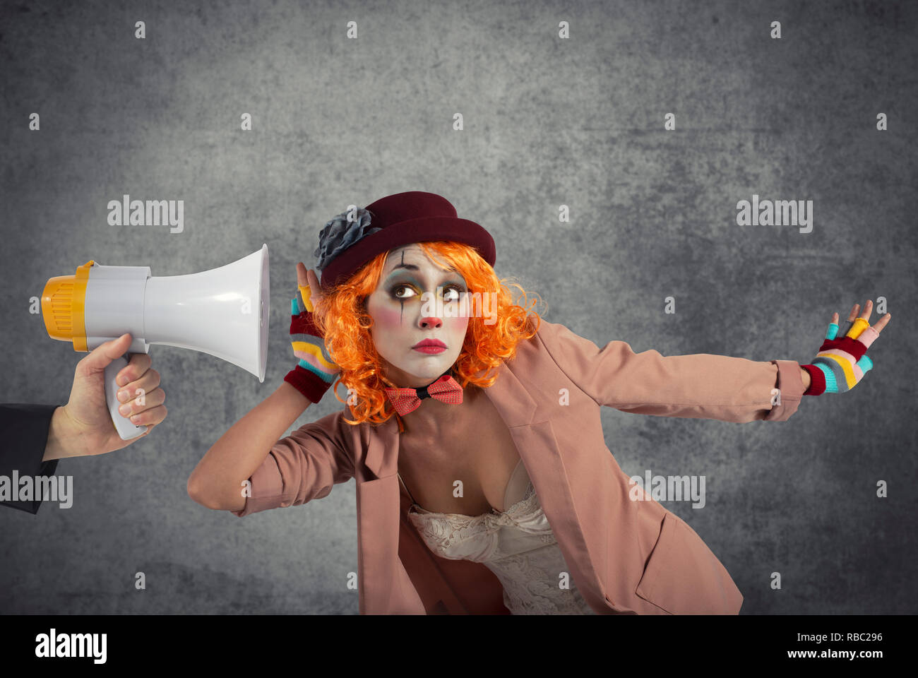 Funny clown sente un megafono con un messaggio Foto Stock