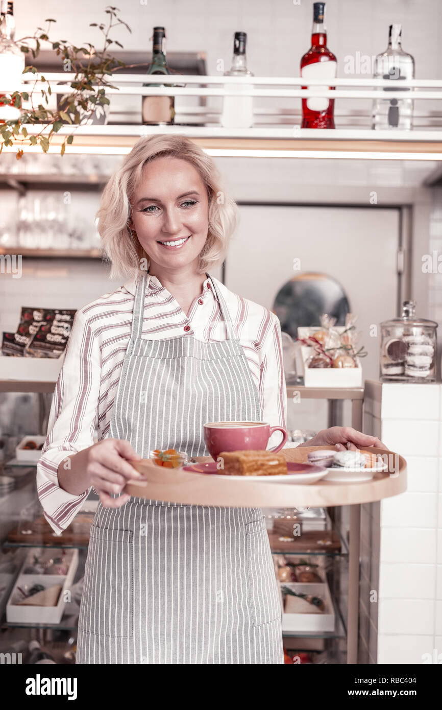 Felice allegro cameriera tenendo un vassoio con la colazione Foto Stock