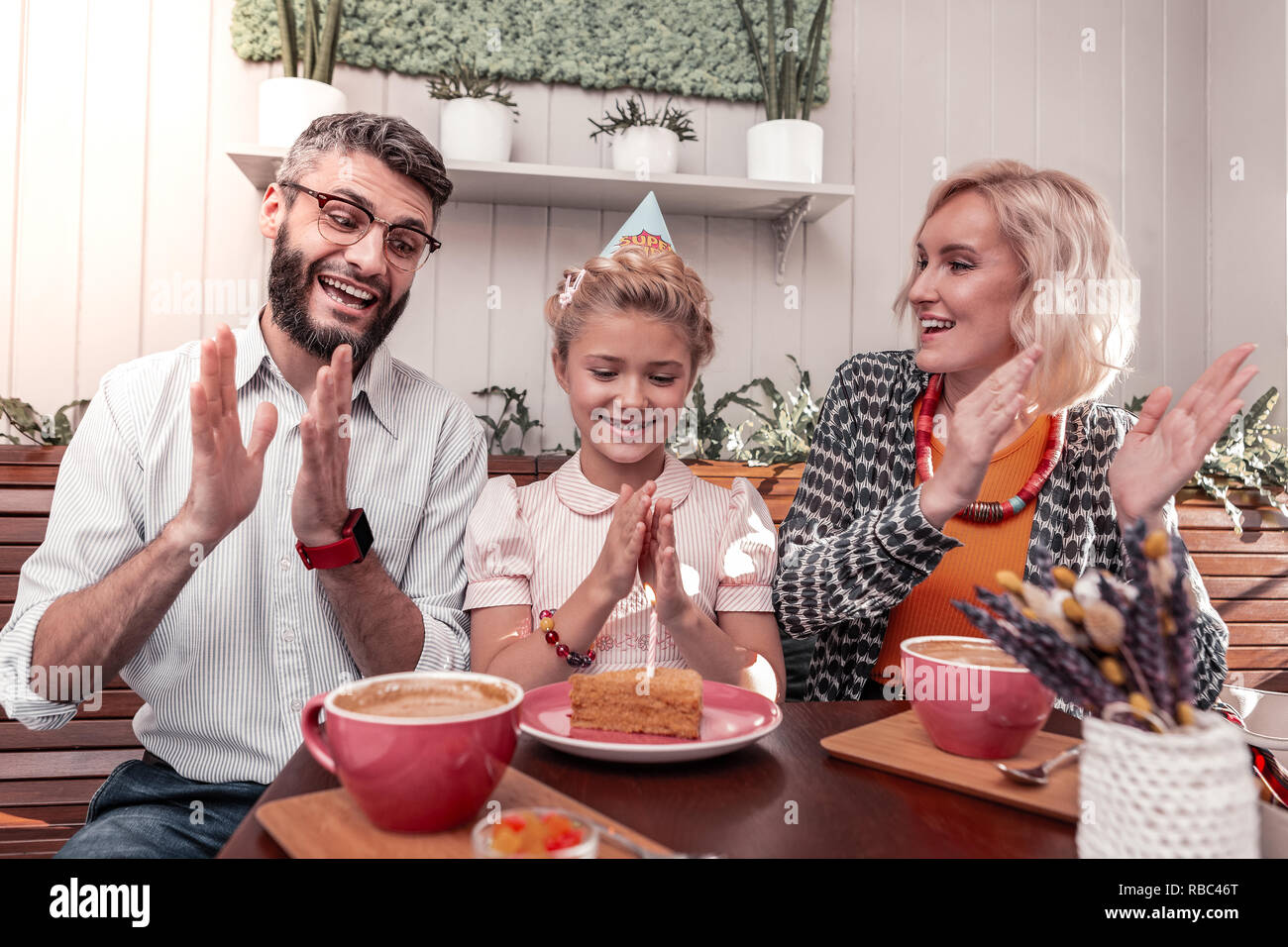 Felice ragazza positivo battendo le mani nelle sue mani Foto Stock