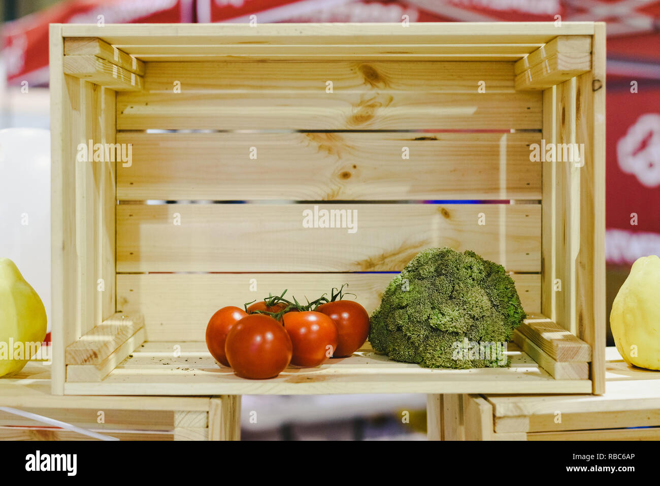 Scatola di legno quasi vuoto, con solo due pomodori e una di broccoli. Foto Stock