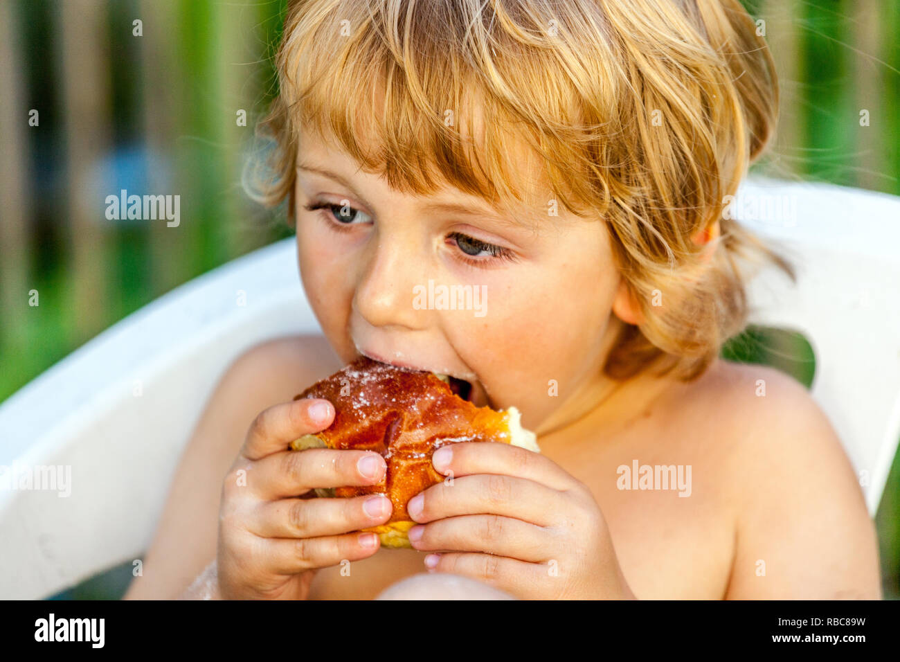Giovane biondo, toddler che mangia la torta, bambino che mangia la torta Foto Stock