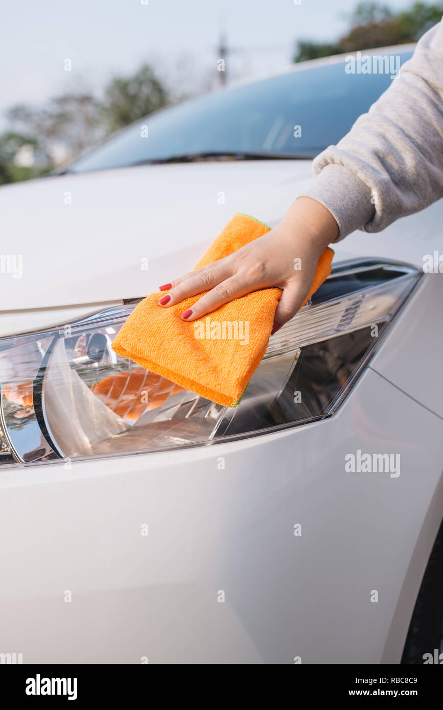Una donna auto pulizia con panno in microfibra, auto che dettaglia (o valeting) concetto Foto Stock