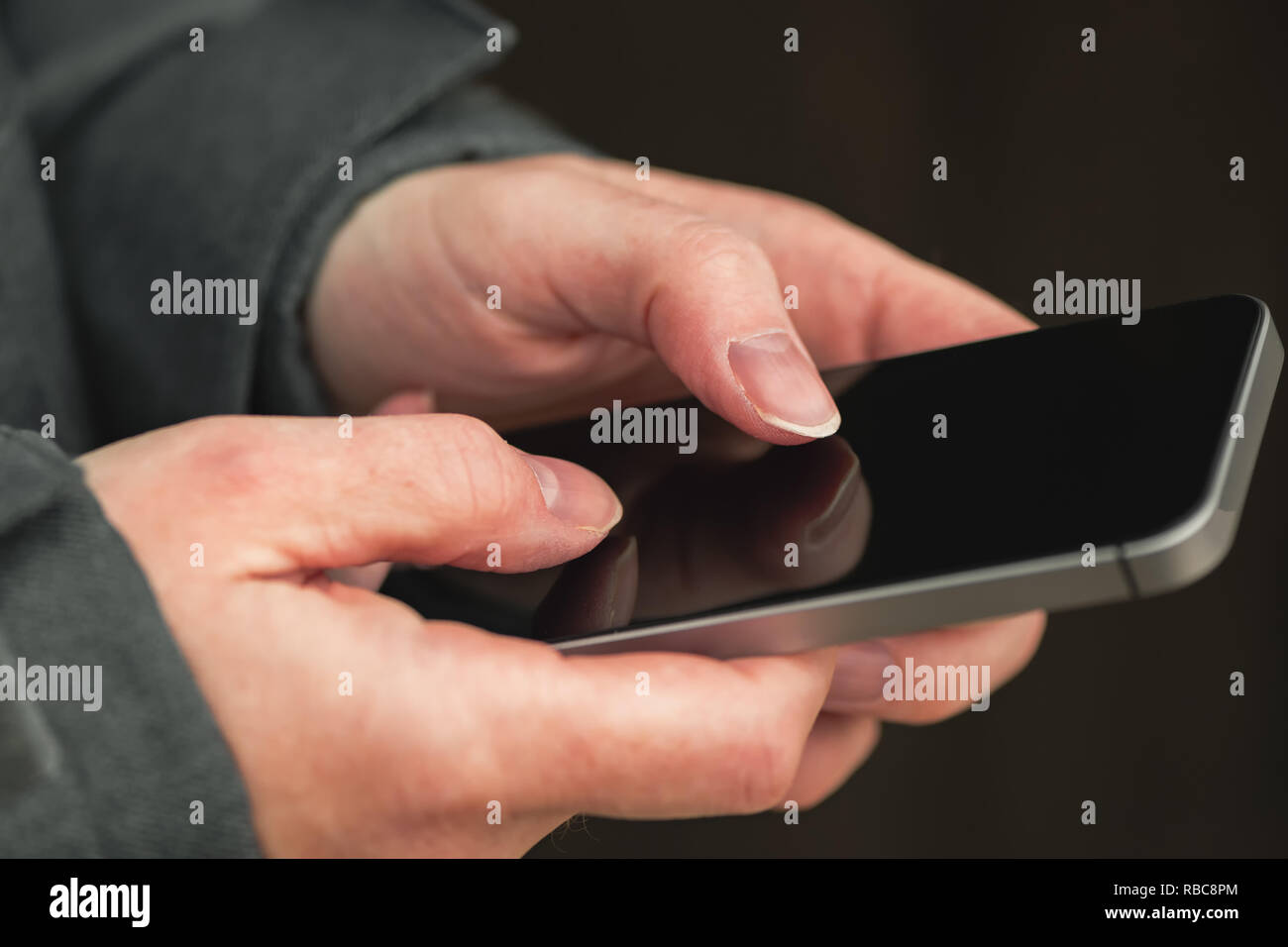 Donna che utilizza il cellulare per inviare messaggi di testo sms in fuori strada nelle fredde giornate invernali, close up delle mani Foto Stock