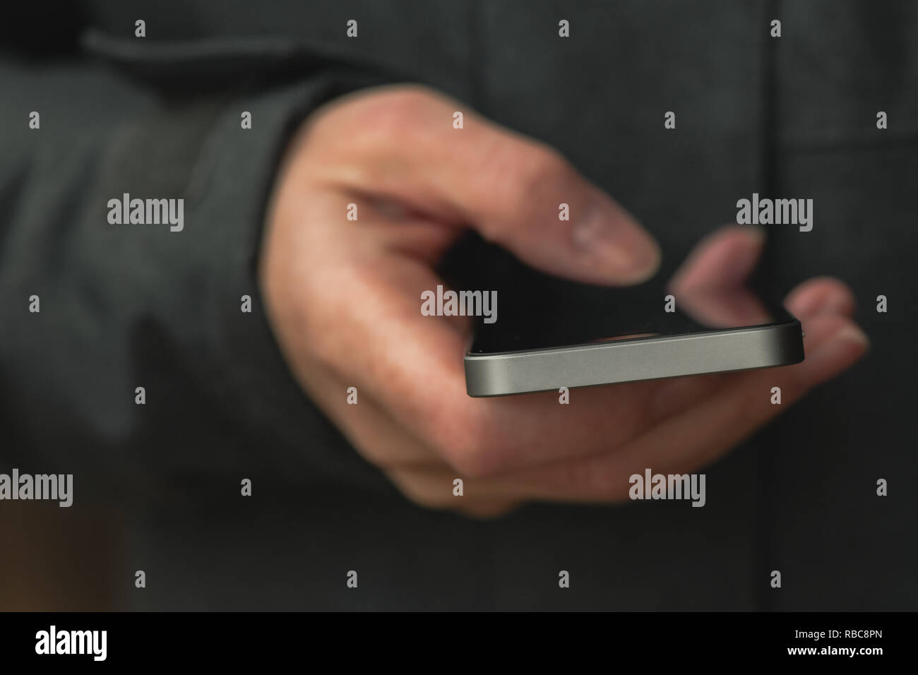 Casual è femmina texting messaggio sul telefono mobile su strada in inverno freddo pomeriggio, close up delle mani Foto Stock