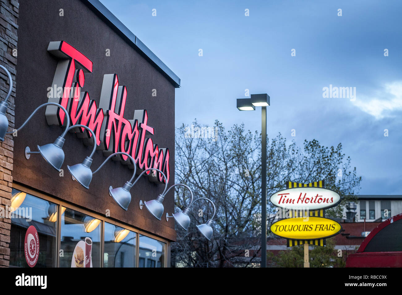 MONTREAL, Canada - 6 Novembre 2018: Tim Hortons logo nella parte anteriore di uno dei loro ristoranti in Quebec con il loro slogan in francese in background. Ti Foto Stock