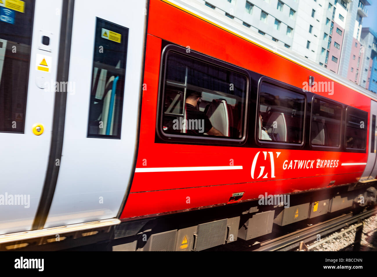Horley, Regno Unito - 28 Giugno 2018: Gatwick Express metro con la metropolitana rossa in treno aeroporto di Londra, la gente seduta all'interno, segno Foto Stock