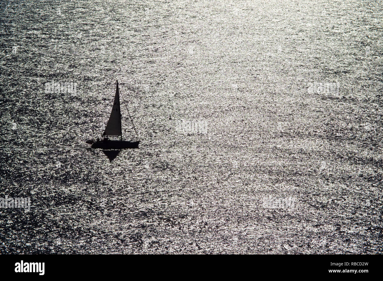 Piccola barca a vela sul mare splendente. Foto Stock