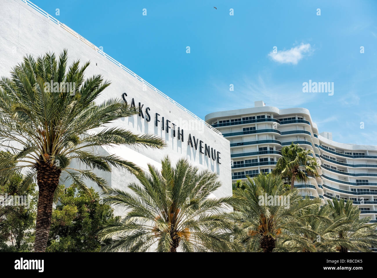 Bal Harbour, Stati Uniti d'America - 8 Maggio 2018: Bay Harbor in Miami Florida verde con palme sulla parte esterna del condominio appartamento edificio dal mall per Saks Fifth Avenu Foto Stock