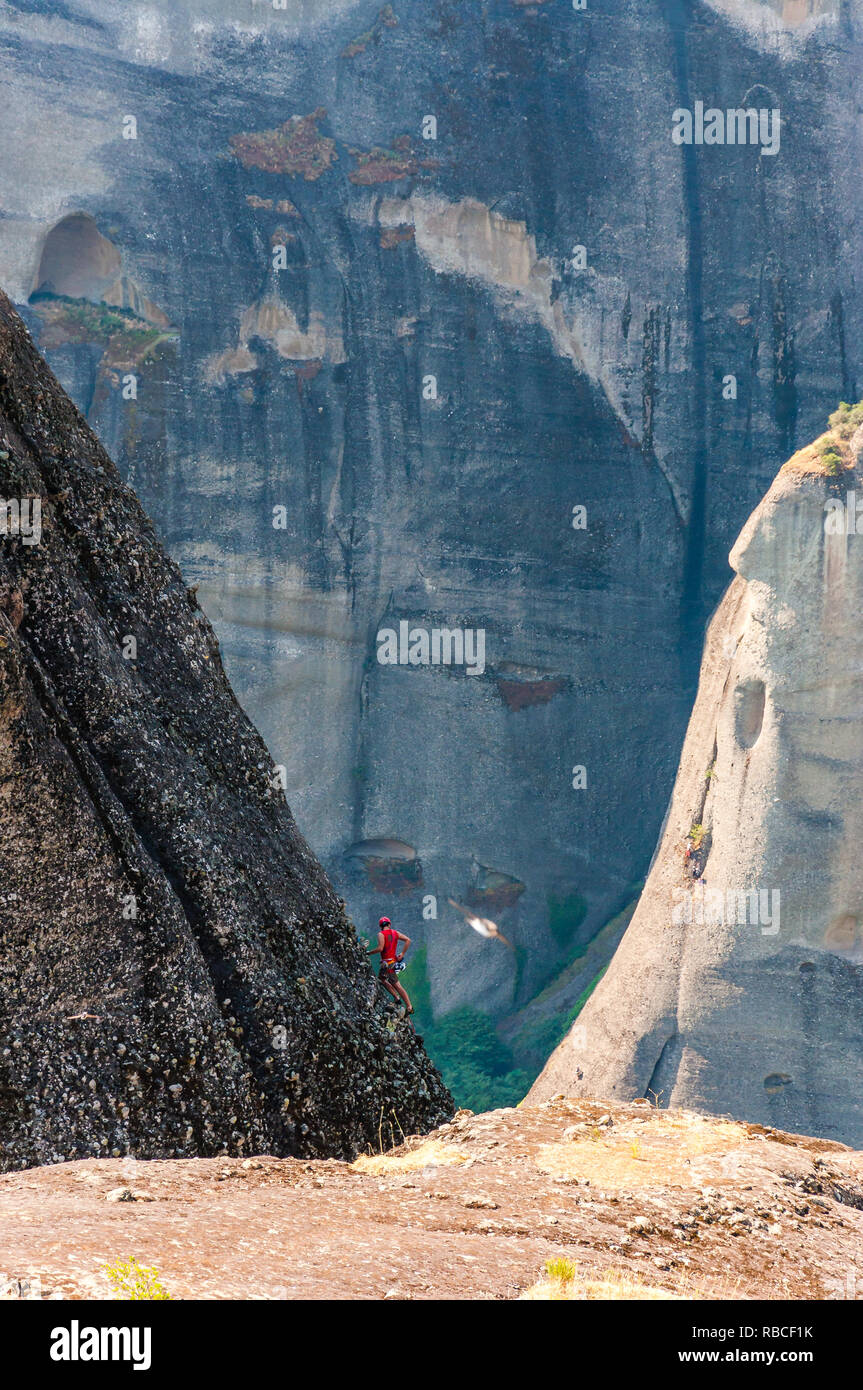 Meteora, Grecia - 16 Giugno 2013: Extreme rocciatore salendo sul picco di una meteora formazioni rocciose scogliere Foto Stock