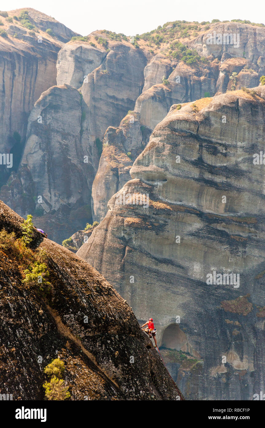 Meteora, Grecia - 16 Giugno 2013: Extreme rocciatore salendo sul picco di una meteora formazioni rocciose scogliere Foto Stock