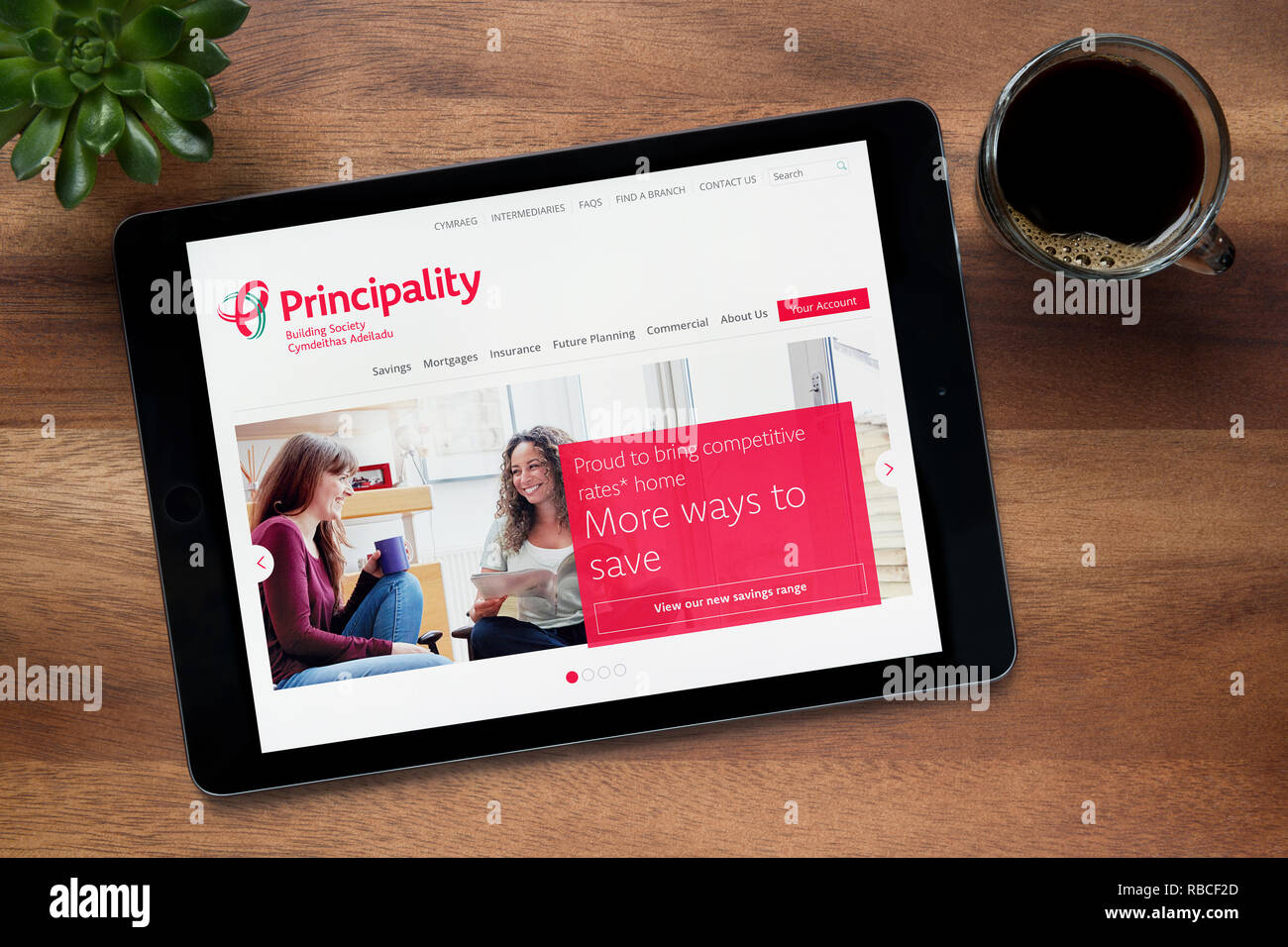 Il sito web del Principato la costruzione della società è visto su un tablet iPad, appoggiato su una tavola di legno (solo uso editoriale). Foto Stock