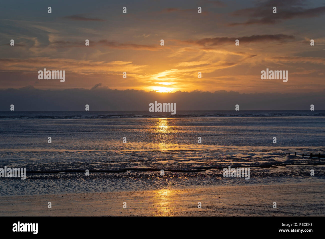 Il sole sorge sopra il canale inglese visto dal Littlestone beach nel Kent. Forecasters hanno avvertito che lo stesso clima che ha scatenato la Bestia da Est e ha portato le temperature di congelamento e di forte neve lo scorso inverno potrebbe tornare quest'anno. Foto Stock