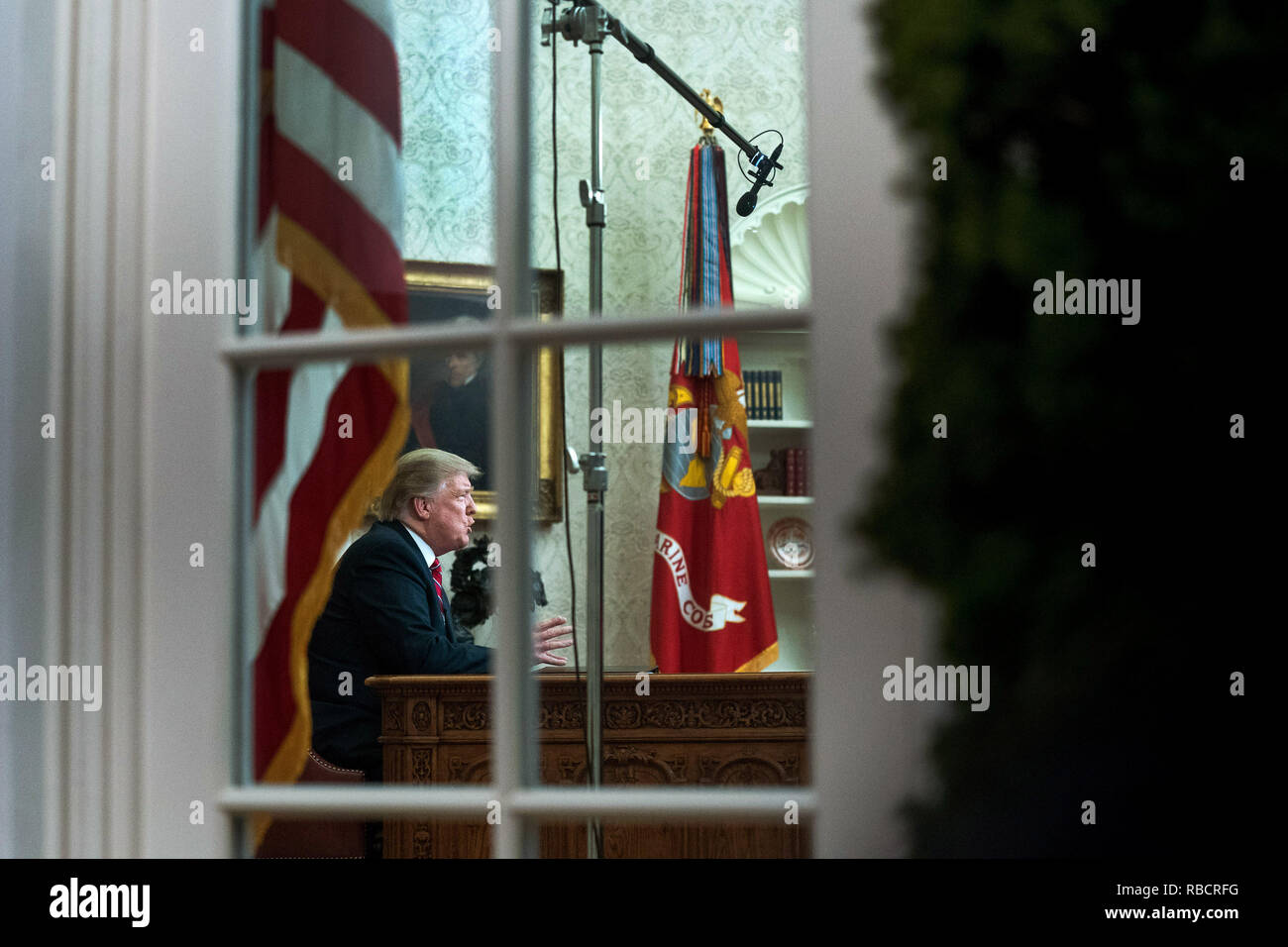 Washington, Stati Uniti d'America. 08 gen 2019. Presidente Donald Trump è visto attraverso la finestra dell'Ufficio ovale come egli offre un indirizzo primetime sul governo di spegnimento e la sua richiesta di finanziamenti per oltre 5 miliardi di dollari per un confine meridionale del muro, alla Casa Bianca di Washington, DC Credito: Kevin Dietsch/Piscina via CNP | Utilizzo di credito in tutto il mondo: dpa/Alamy Live News Foto Stock