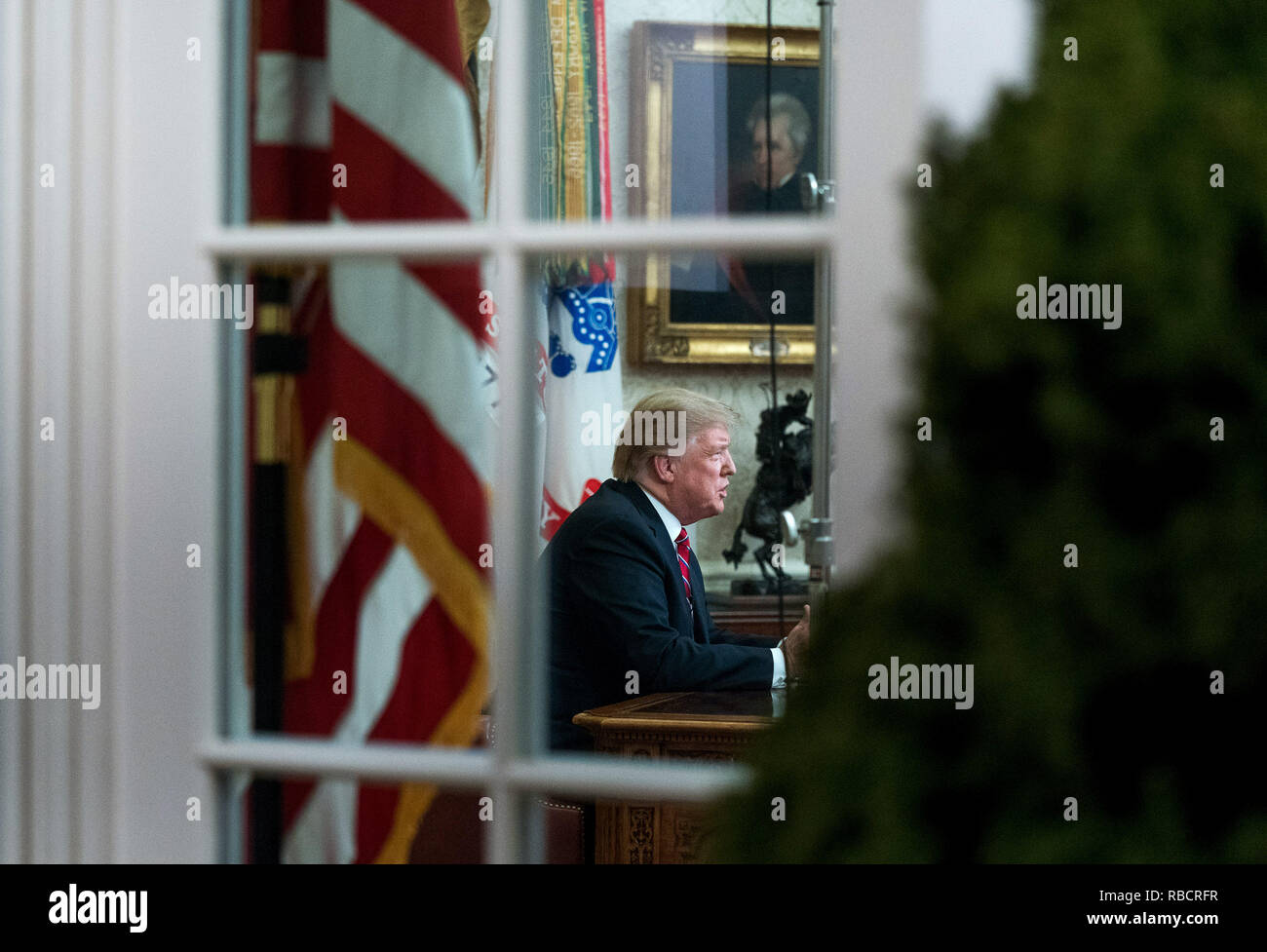 Washington, Stati Uniti d'America. 08 gen 2019. Presidente Donald Trump è visto attraverso la finestra dell'Ufficio ovale come egli offre un indirizzo primetime sul governo di spegnimento e la sua richiesta di finanziamenti per oltre 5 miliardi di dollari per un confine meridionale del muro, alla Casa Bianca di Washington, DC Credito: Kevin Dietsch/Piscina via CNP | Utilizzo di credito in tutto il mondo: dpa/Alamy Live News Foto Stock